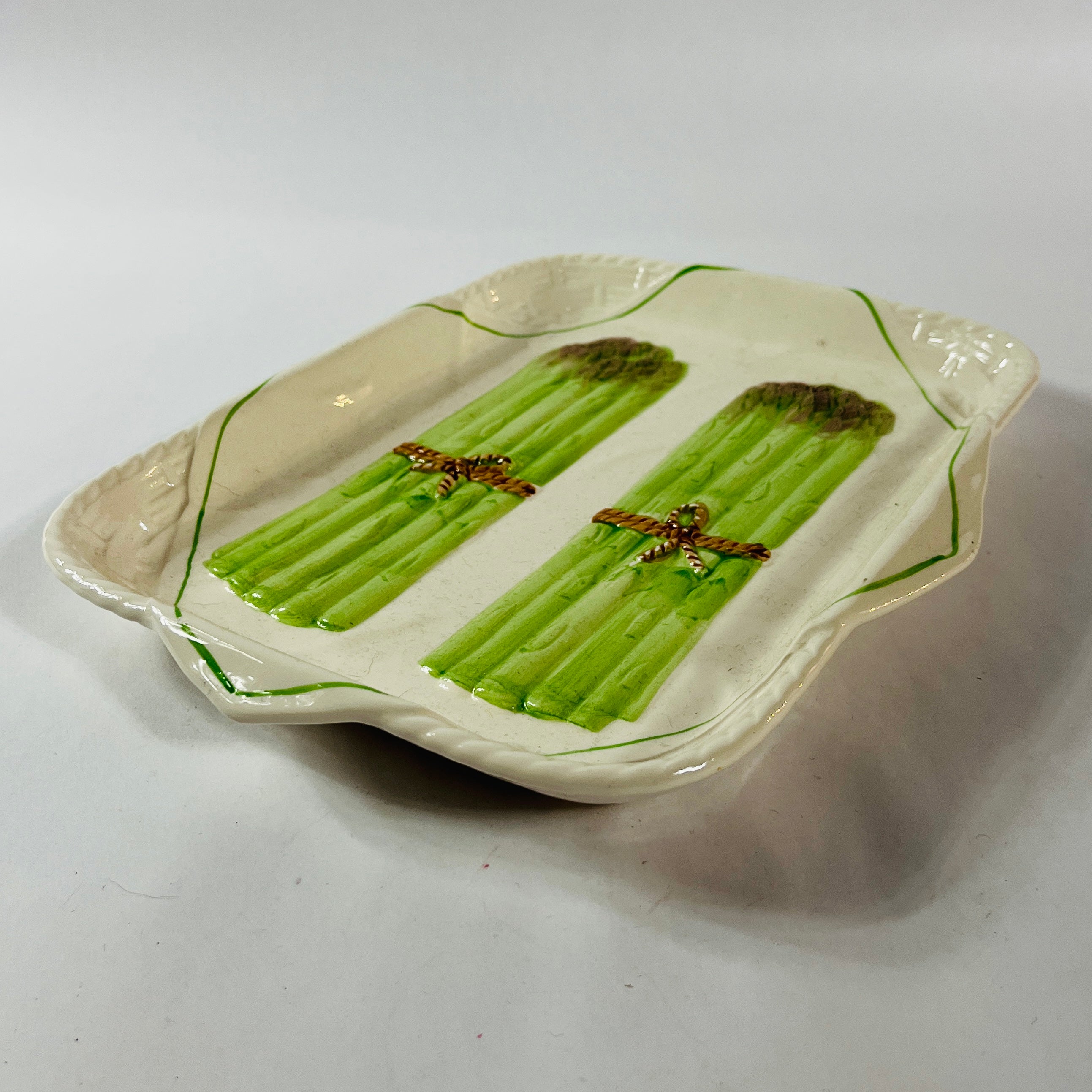 Vintage ceramic serving platter featuring raised green asparagus bundles with decorative detail