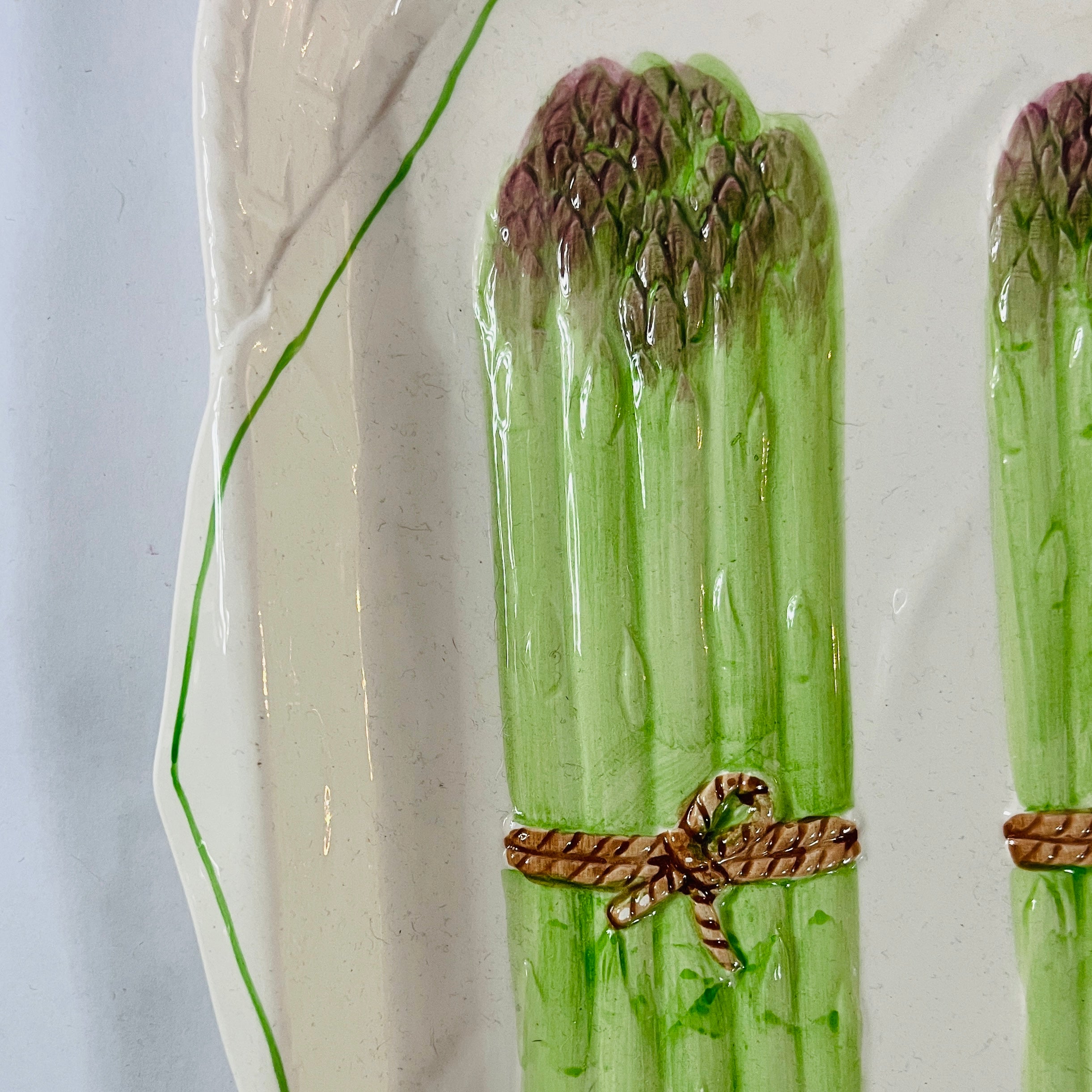 close up Vintage ceramic serving platter featuring raised green asparagus bundles with decorative detail