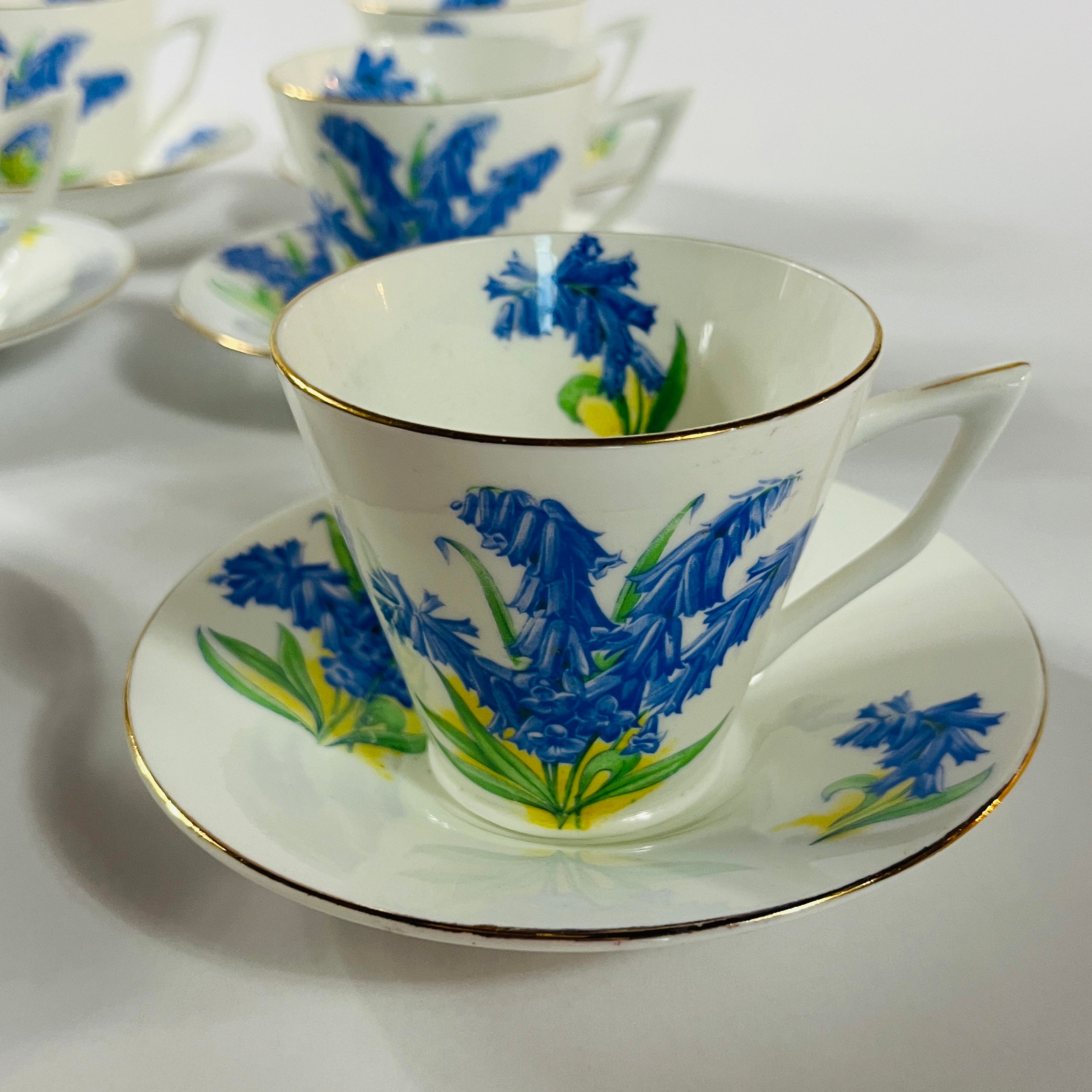 Vintage English bone china cup, saucer, and dessert plate with bluebell floral pattern and gold rim