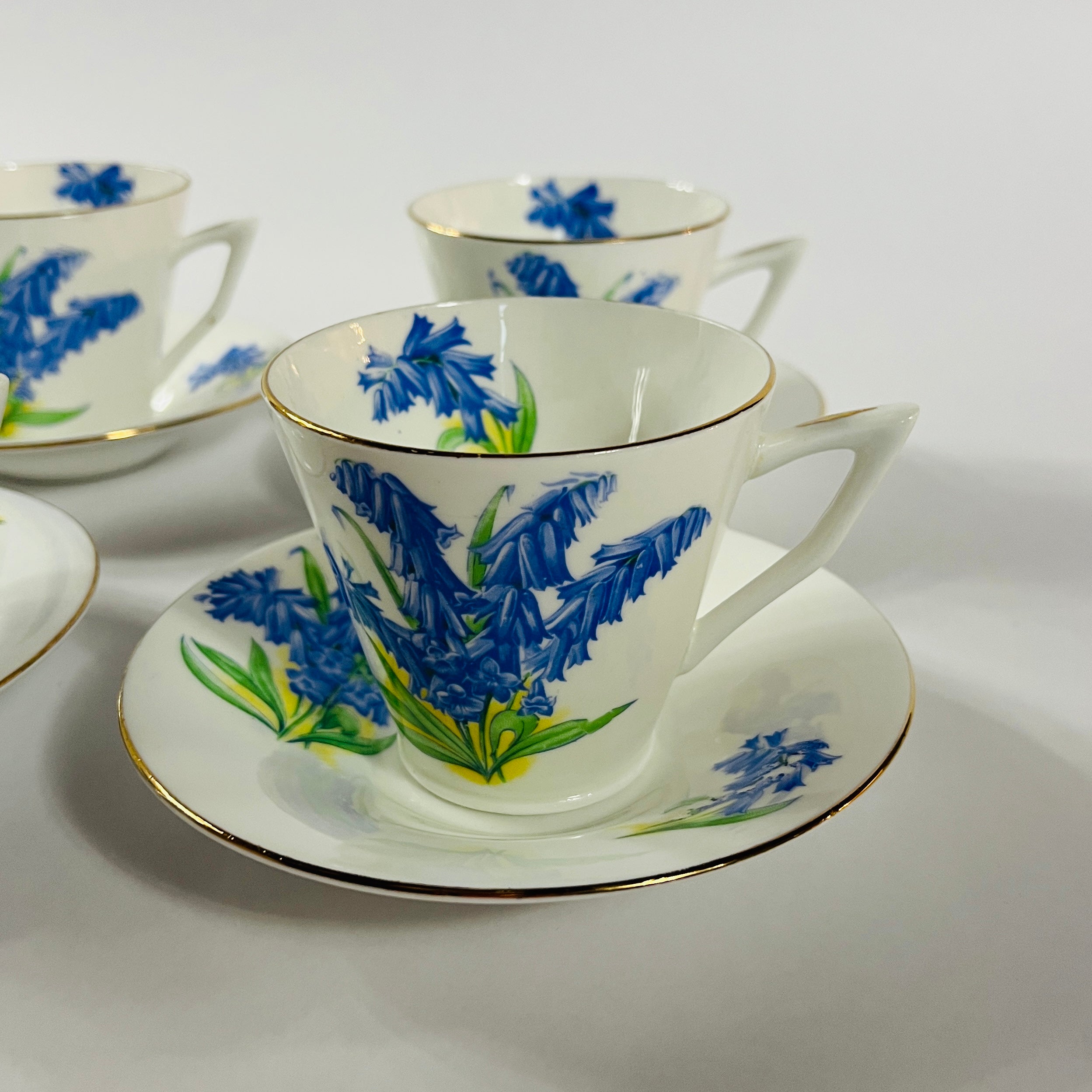 Vintage English bone china cup, saucer, and dessert plate with bluebell floral pattern and gold rim