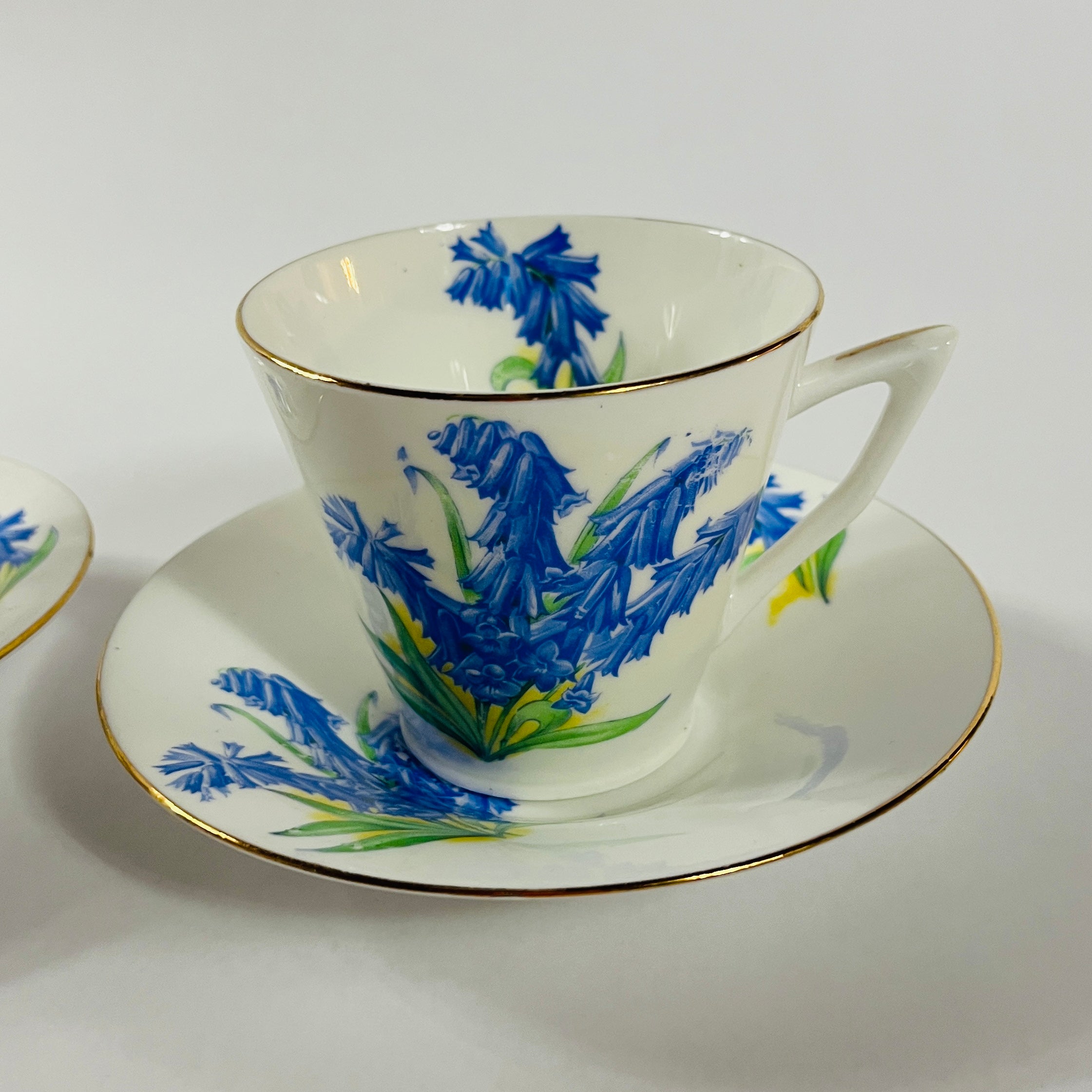 Vintage English bone china cup, saucer, and dessert plate with bluebell floral pattern and gold rim