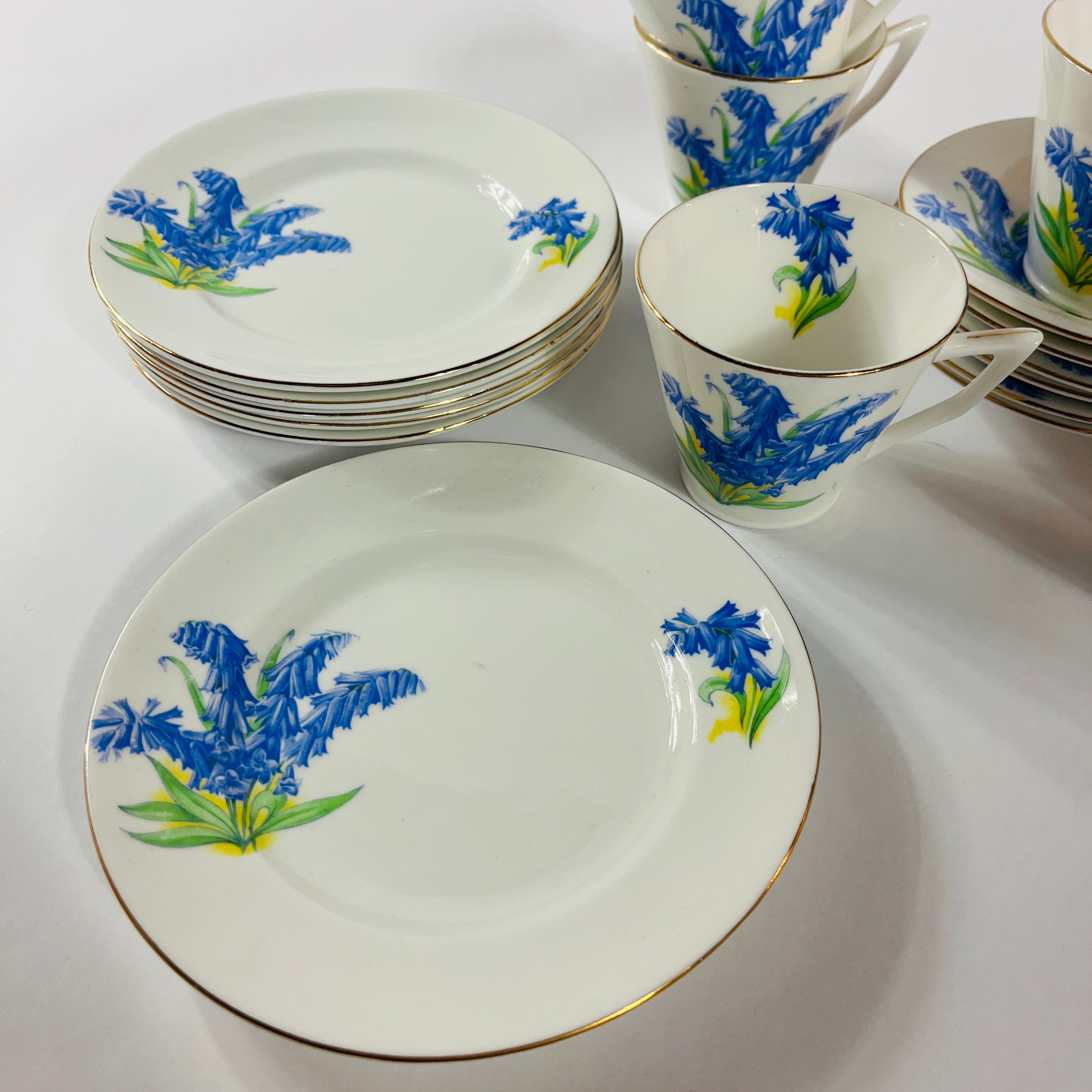 Vintage English bone china cup, saucer, and dessert plate with bluebell floral pattern and gold rim
