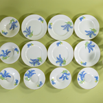 Overhead view of vintage English bone china bluebell dessert set with cups, saucers, and plates arranged together