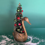 a Vintage Tall Brass Swan w/ Red/Green Christmas Tree Centerpiece against a green background. 