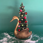 a Vintage Tall Brass Swan w/ Red/Green Christmas Tree Centerpiece against a green background. 