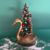 a Vintage Tall Brass Swan w/ Red/Green Christmas Tree Centerpiece against a green background. 