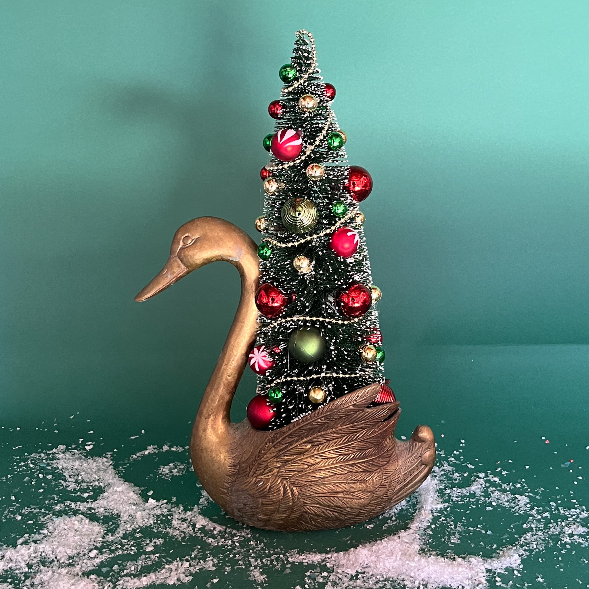 a Vintage Tall Brass Swan w/ Red/Green Christmas Tree Centerpiece against a green background. 