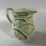 Vintage ceramic pitcher with sculpted leafy design and green hand-painted details