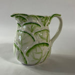 Vintage ceramic pitcher with sculpted leafy design and green hand-painted details