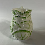Vintage ceramic pitcher with sculpted leafy design and green hand-painted details