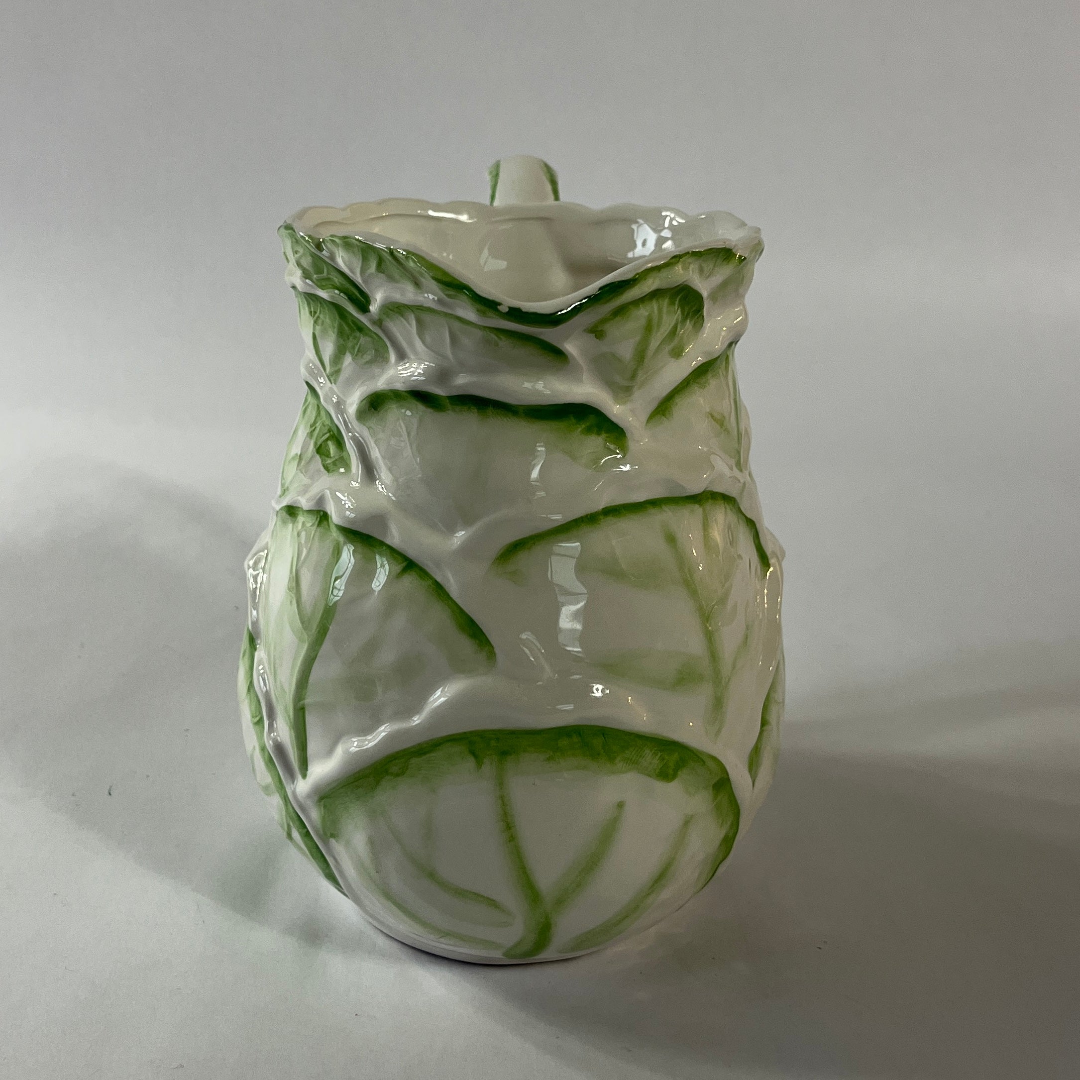 Vintage ceramic pitcher with sculpted leafy design and green hand-painted details