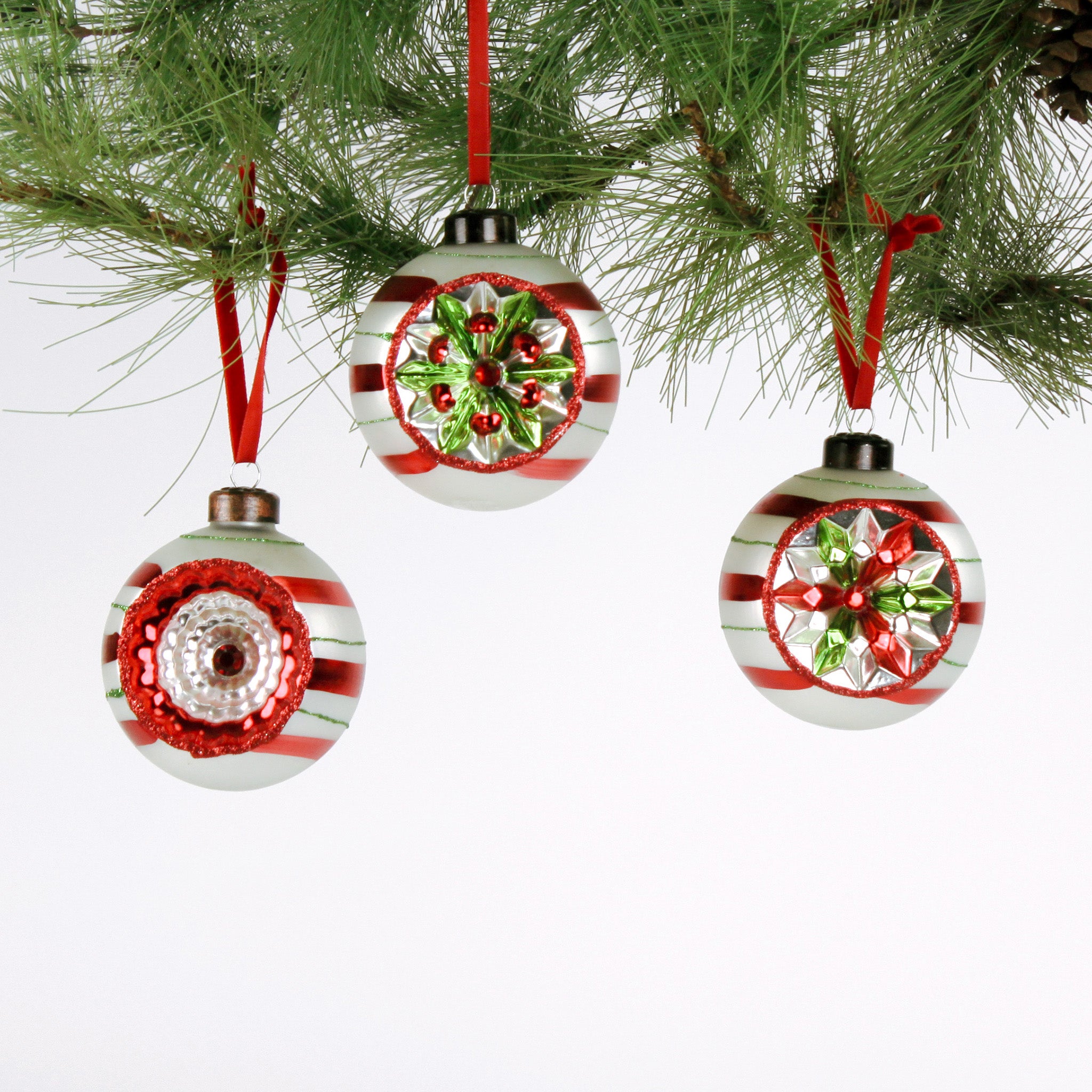 Set of three vintage-style glass Christmas ball ornaments with red, white, and green candy stripe patterns and reflective floral accents