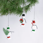 Set of three vintage-style snowman ornaments, each wearing a colorful top hat and scarf