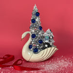 a Vintage White/Gold Ceramic Swan w/ Silver/Blue Glitter Christmas Trees Centerpiece against a red background. 
