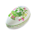 Decorative egg-shaped container with floral and frog design on a white background