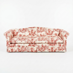 A classic three-seat sofa upholstered in a red and cream toile pattern, set against a plain white studio background.