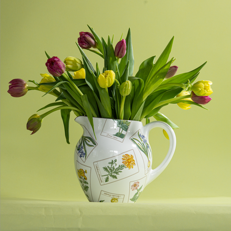 a vintage tiffany and co pitcher with floral motifs and filled with tulips. 