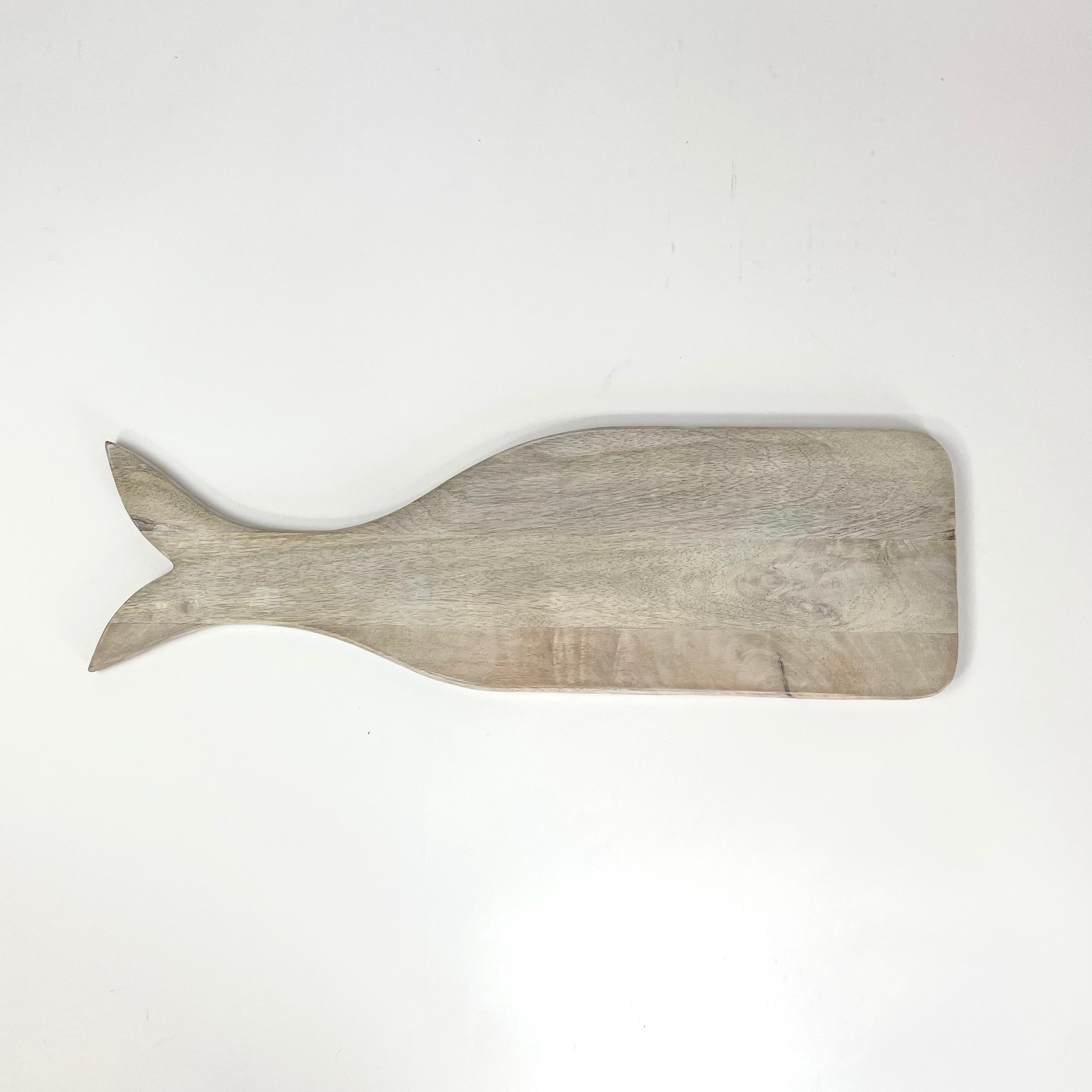 A wood charcuterie board in the shape of a whale