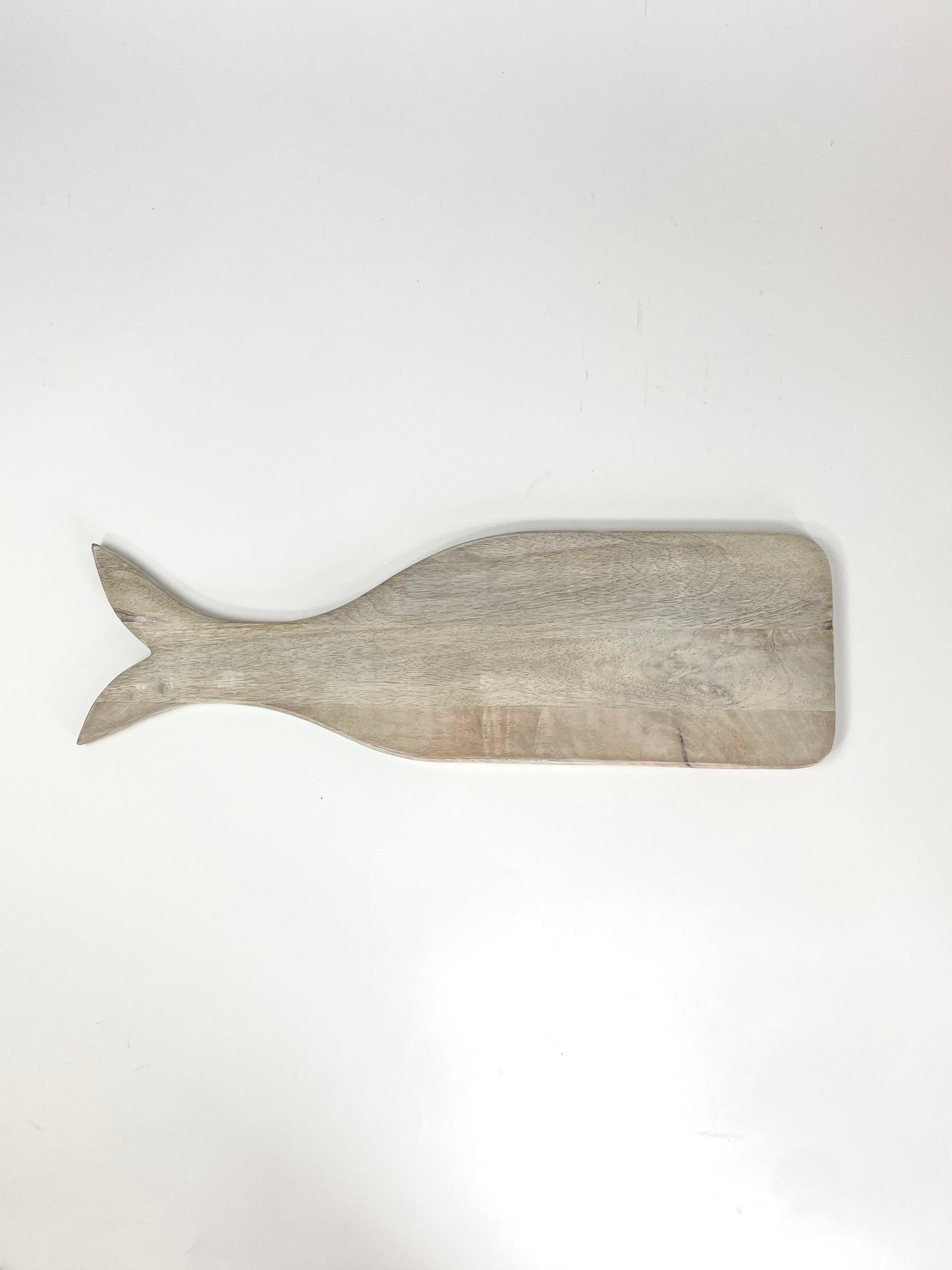 A wood charcuterie board in the shape of a whale