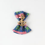 loth napkin with pink whale and green seaweed print styled with a gold anchor napkin ring.