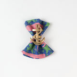 loth napkin with pink whale and green seaweed print styled with a gold anchor napkin ring.