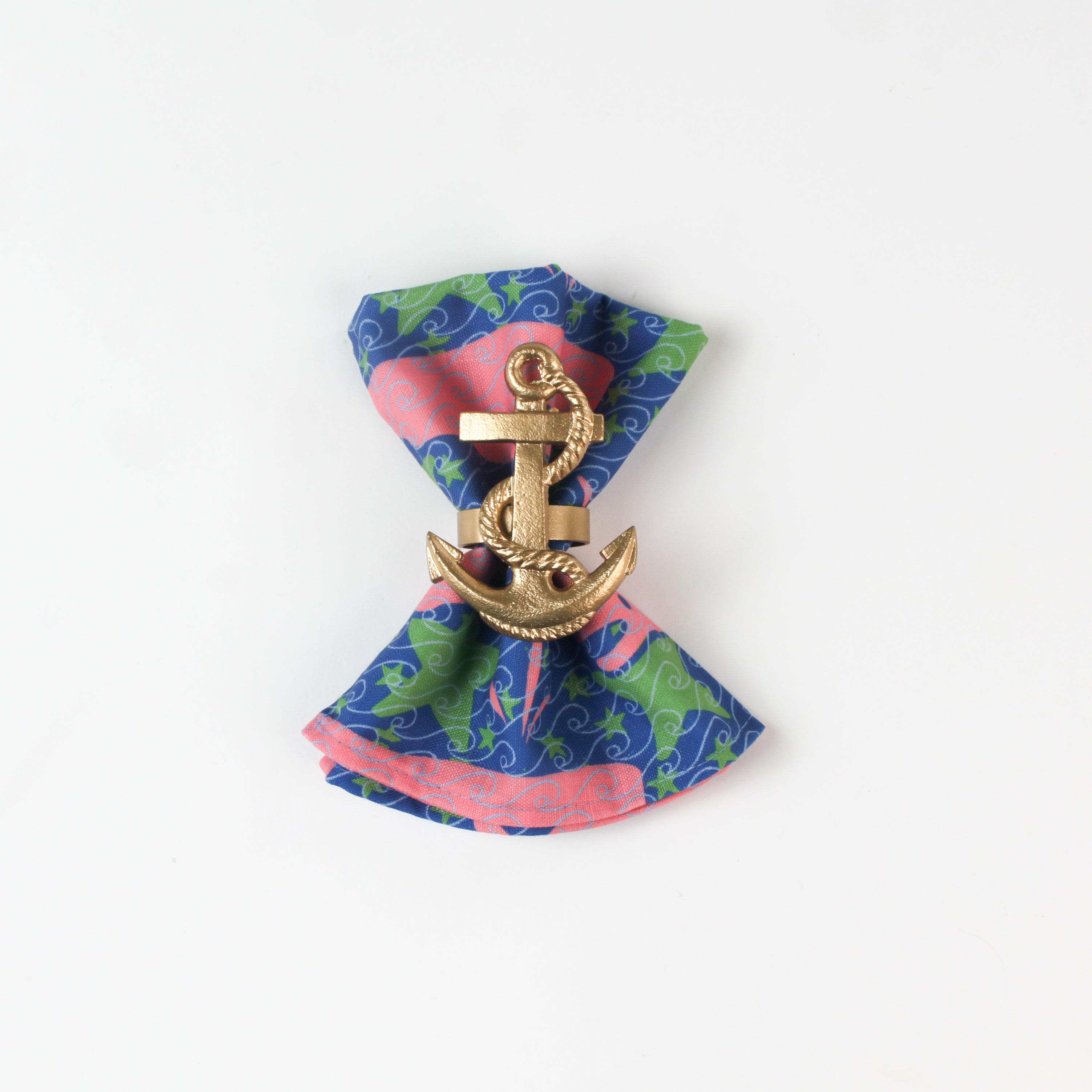loth napkin with pink whale and green seaweed print styled with a gold anchor napkin ring.