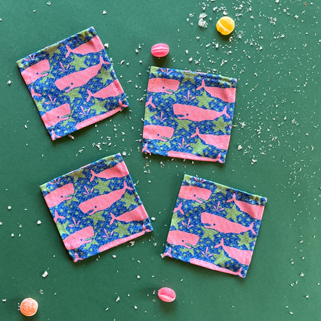 Whale of a Time cloth cocktail napkins on a green background with candies.