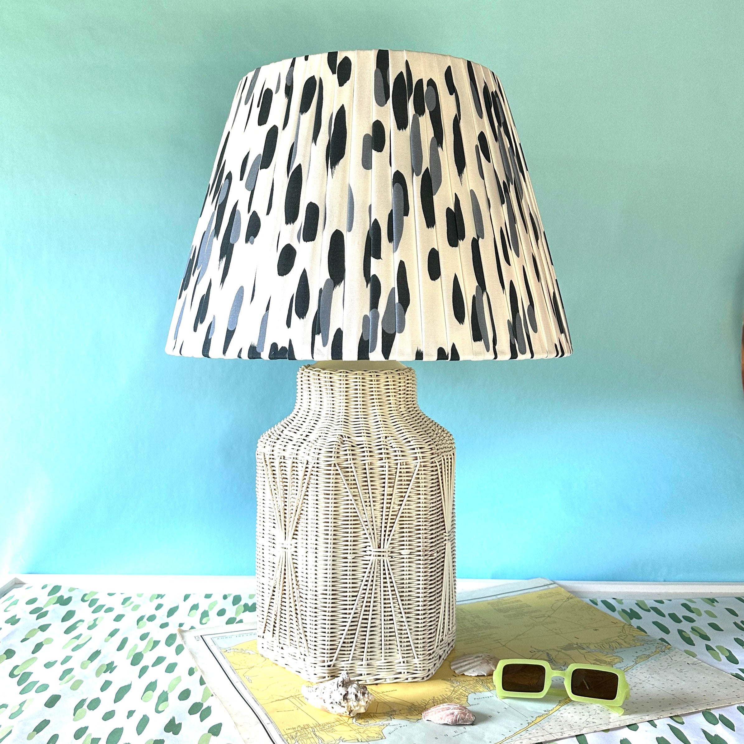 A vintage blue and white lamp featuring a white rattan base and a blue and white patterned lampshade.