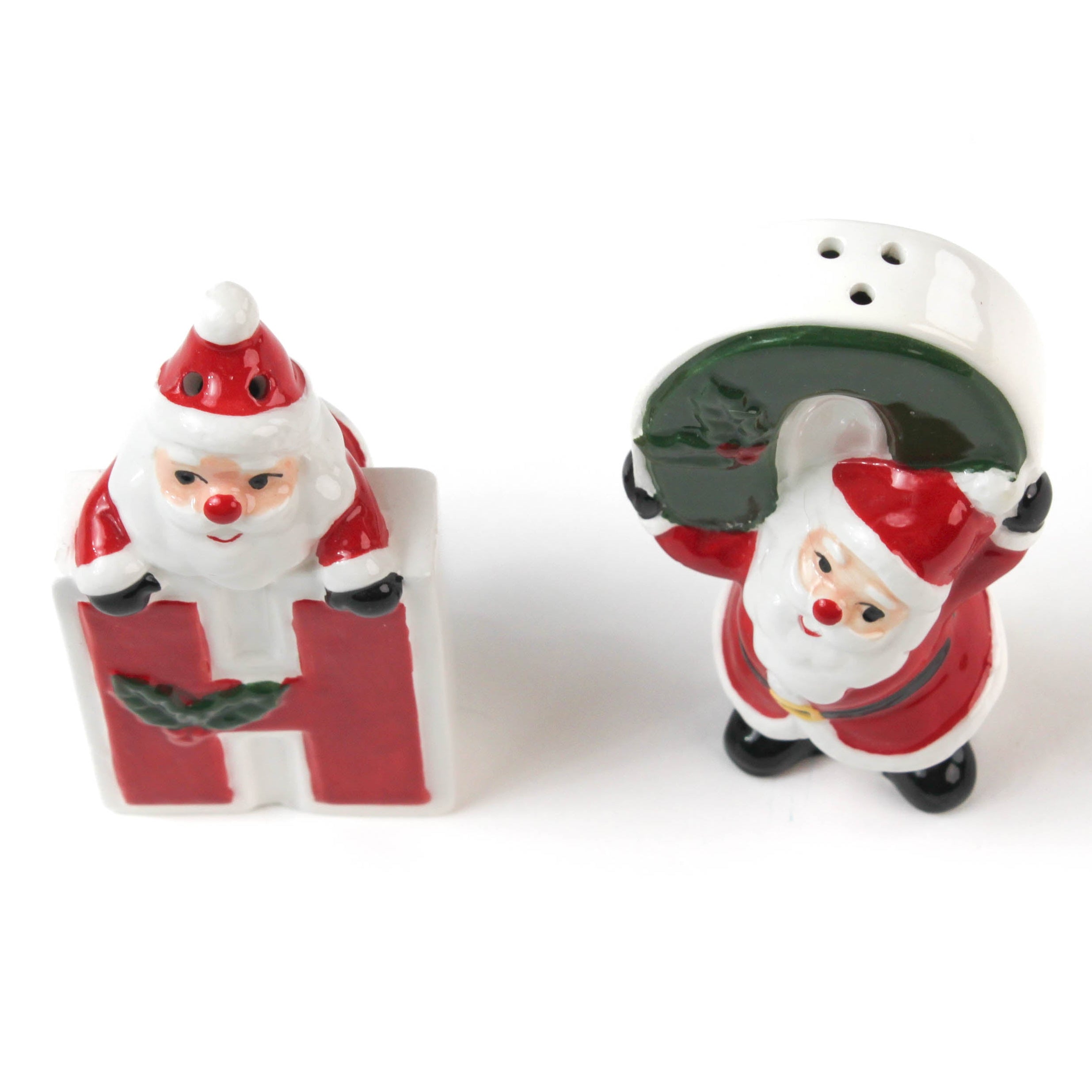 Two ceramic christmas salt and pepper shakers shaped like the letters 'H' and 'O' with Santa Claus figures on a white background.