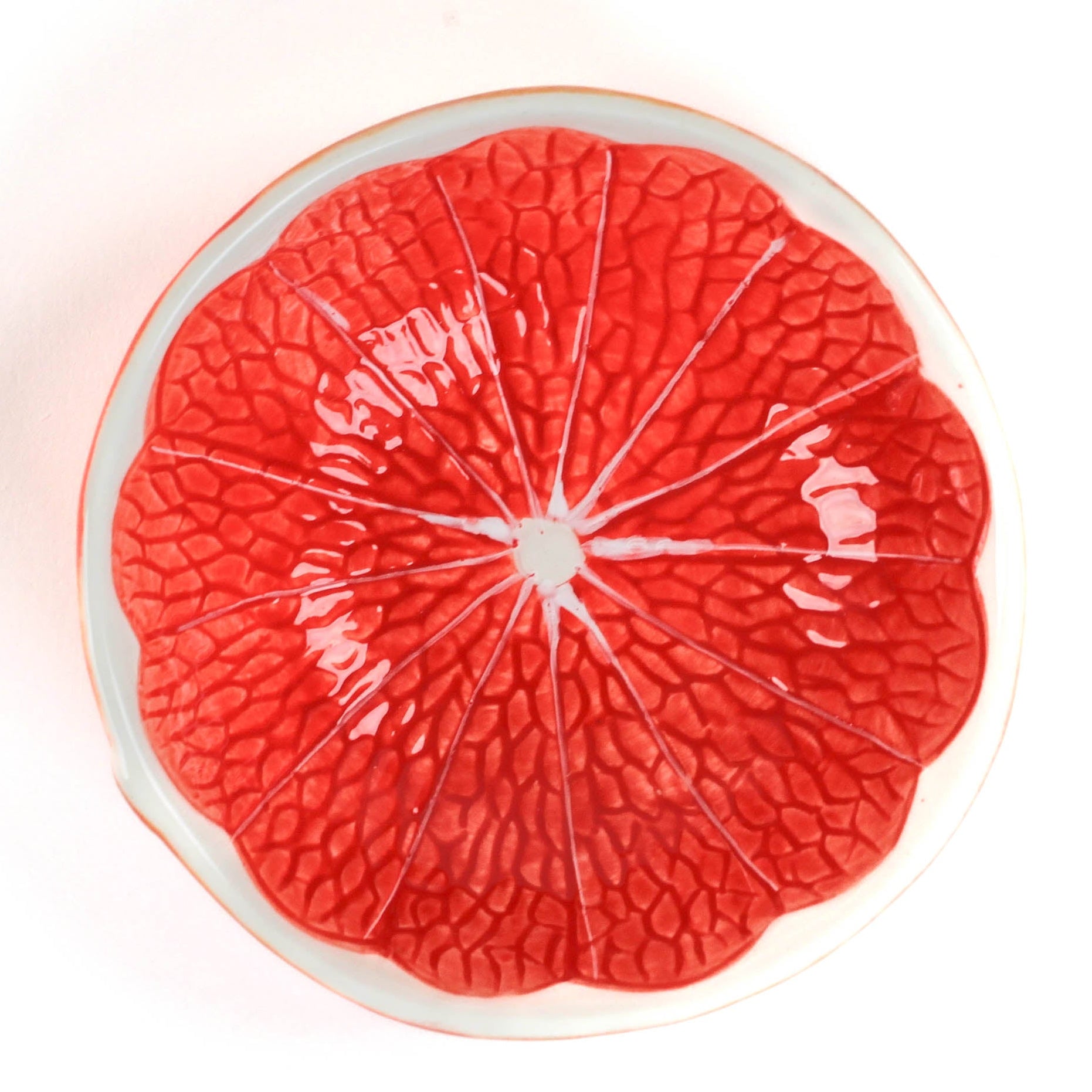 grapefruit shaped ceramic bowls with a textured surface on a white background