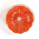 Decorative orange plate with textured orange design on a white background