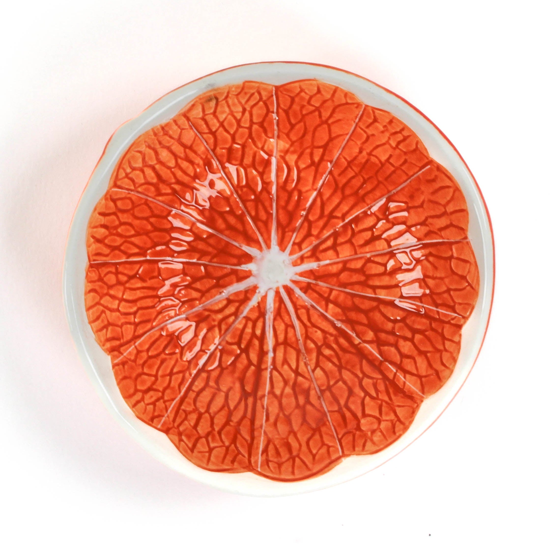 Decorative orange plate with textured orange design on a white background