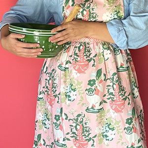 Person wearing Madcap Cottage Floral  holding a green bowl with a pink background
