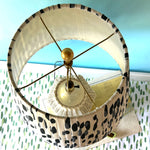 An aerial view of a vintage blue and white lamp featuring a white rattan base and a blue and white patterned lampshade.