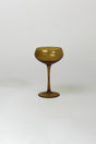 an amber colored coupe glass on a white background