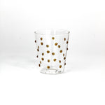 Clear glass with gold polka dots on a white background