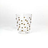 Clear glass with gold polka dots on a white background