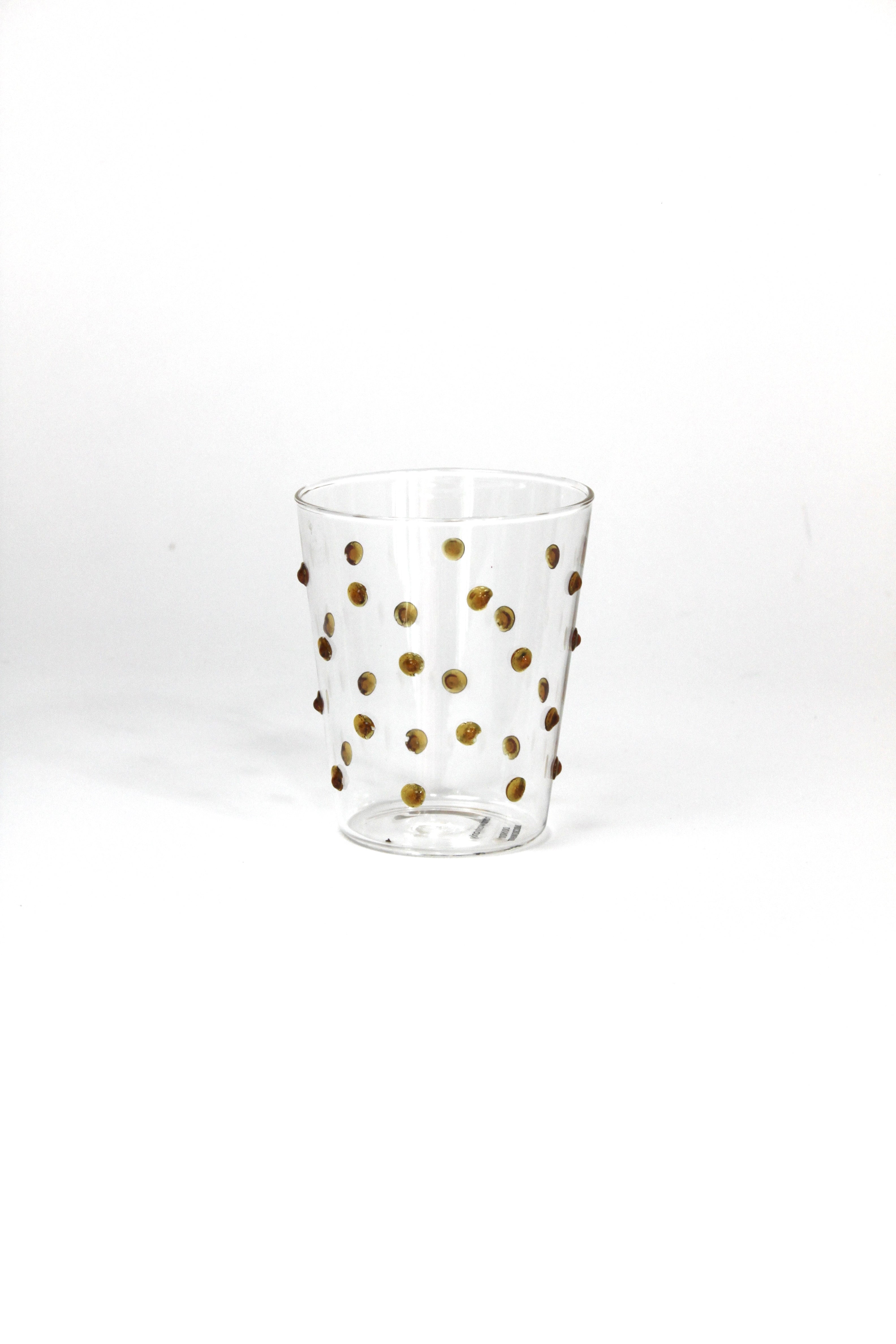 Clear glass with gold polka dots on a white background