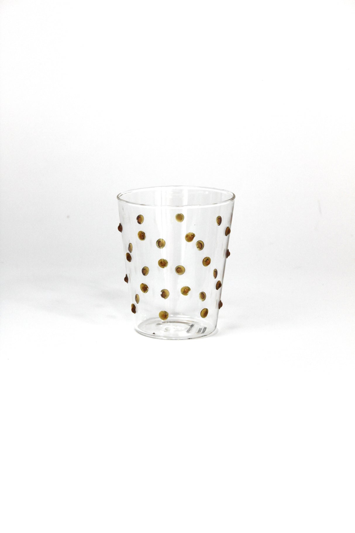 Clear glass with gold polka dots on a white background