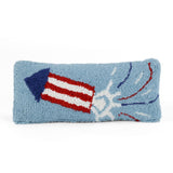 Rectangular blue decorative pillow with a hooked texture featuring a red, white, and blue fireworks rocket design, shown on a white background.