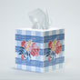 a blue gingham tissue box cover with a central floral motif on each side.