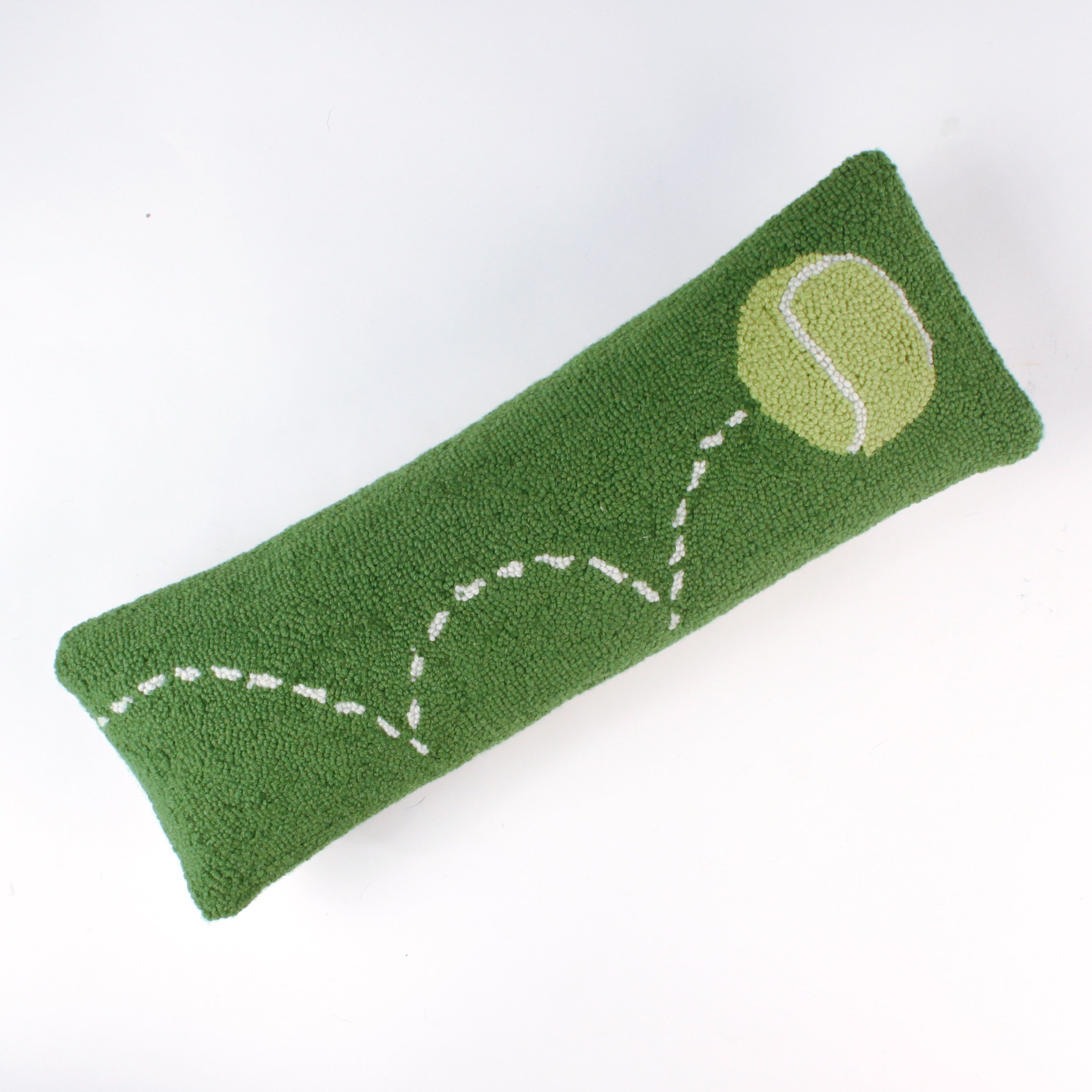 Rectangular green decorative pillow with a hooked texture, featuring a yellow tennis ball and a white dashed line illustrating its bounce pattern.