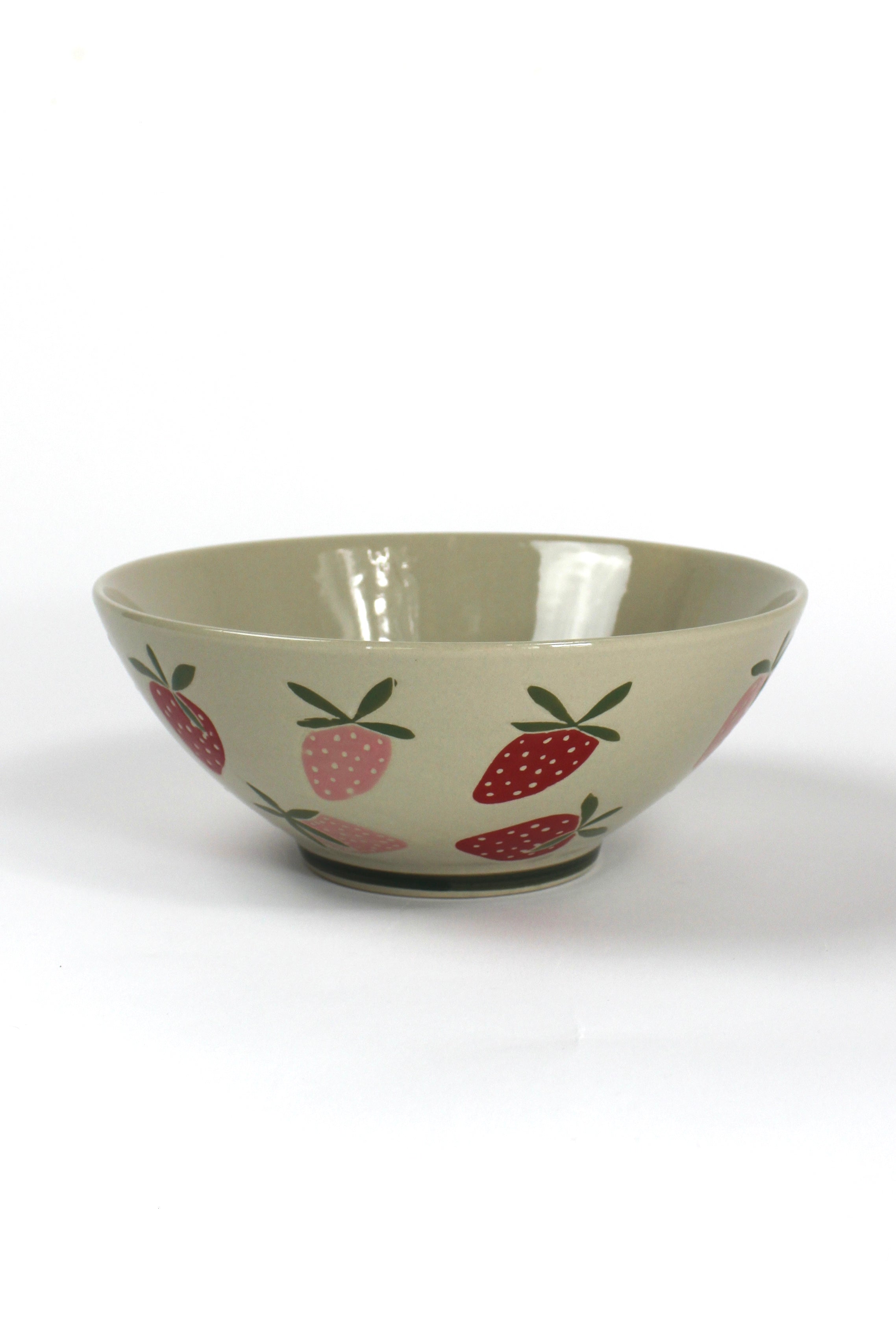 a large beige strawberry serving bowl decorated with pink and red strawberry motifs.