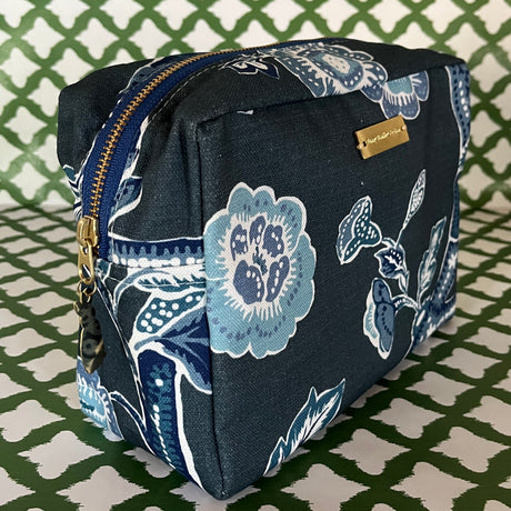 Front 3/4 view of Temple Garden toiletry bag in navy blue features light blue floral motif.