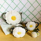 a vintage daisy creamer set featuring three ceramic creamer pieces with large daisies on the sides. 