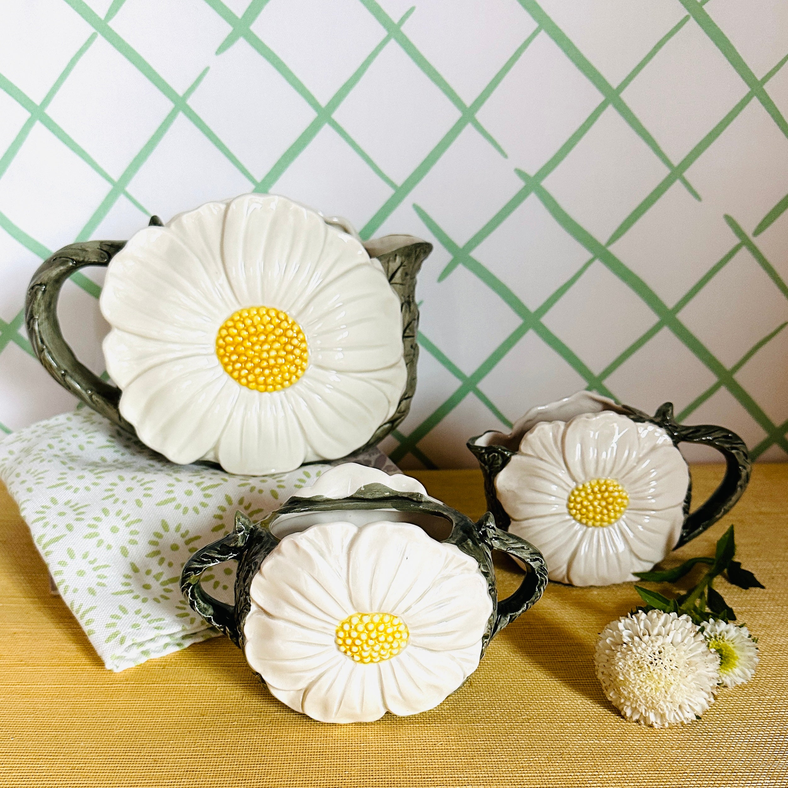 a vintage daisy creamer set featuring three ceramic creamer pieces with large daisies on the sides. 