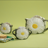a vintage daisy creamer set featuring three ceramic creamer pieces with large daisies on the sides. 