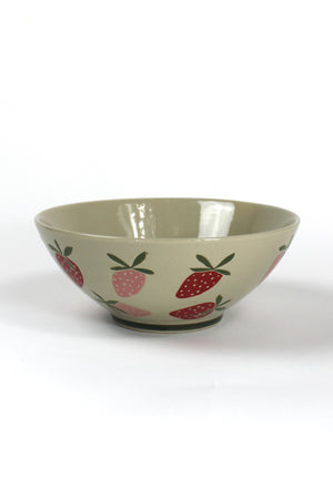 a large beige strawberry serving bowl decorated with pink and red strawberry motifs.