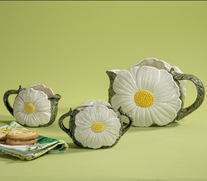 a vintage daisy creamer set featuring three ceramic creamer pieces with large daisies on the sides. 