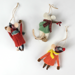 back of Three felt mouse ornaments dressed for winter—one in a red coat and plaid hat tossing a snowball, one in an orange coat with a yellow scarf holding a snowball, and one in a green sweater holding red berries—lying in white surface.

